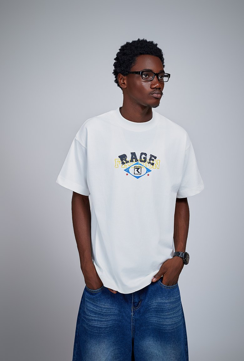 Kanann in a white Rage tee and baggy jeans against a grey studio backdrop