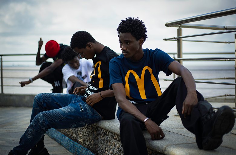 Kanann and friends sitting together on a seaside terrace